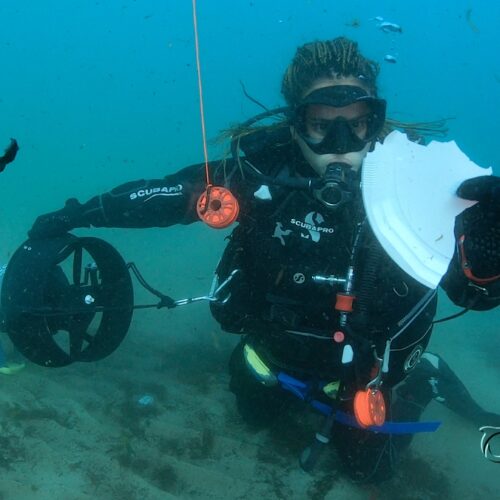 Oceana diver holding a piece of plastic plate.